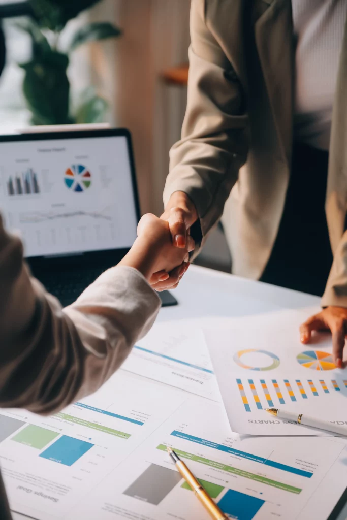 businesswoman-shaking-hands-with-businessman-desk-office